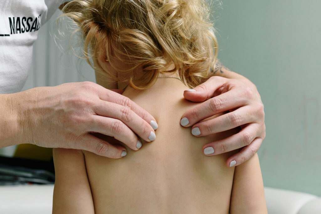 A woman massaging a child s back